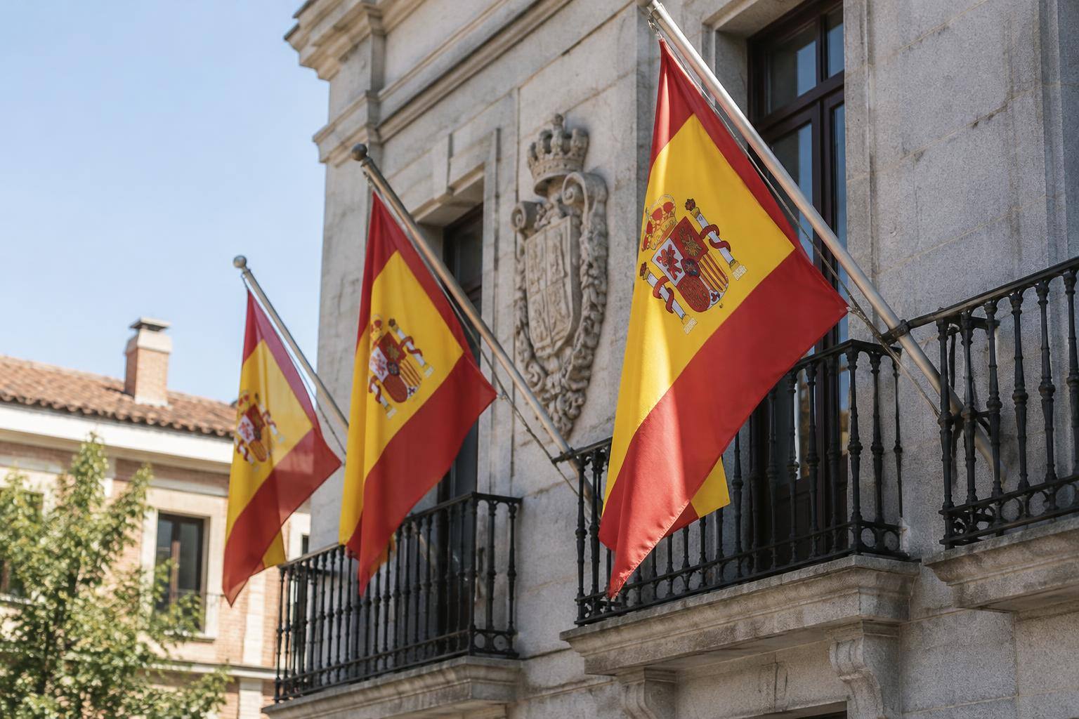 Imagen ilustrativa: Banderas de España en la fachada de un edificio institucional, sin personas reconocibles