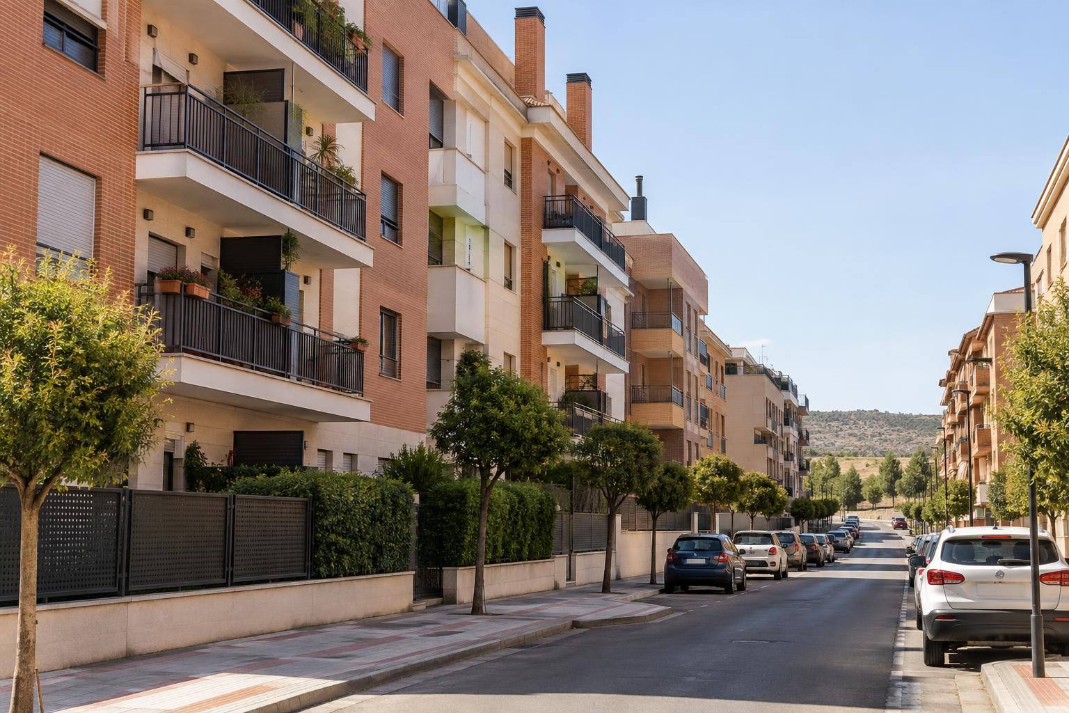 Imagen ilustrativa: fachadas de bloques de viviendas con balcones y una calle residencial, sin personas reconocibles