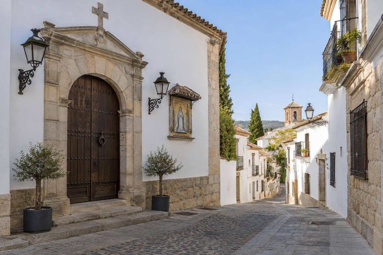 Imagen ilustrativa: Puerta de una capilla y calle de un casco histórico andaluz, sin personas ni cortejos identificables.