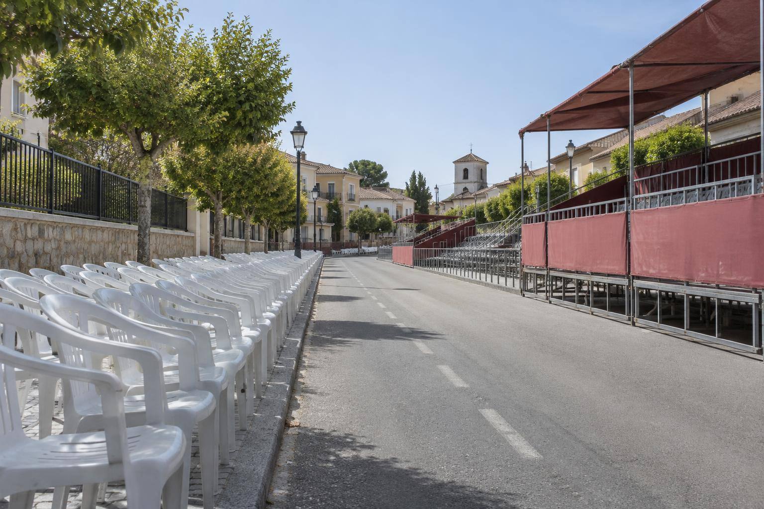 Imagen ilustrativa: Filas de sillas vacías y estructuras de palcos junto a una calle, sin personas ni elementos identificativos.