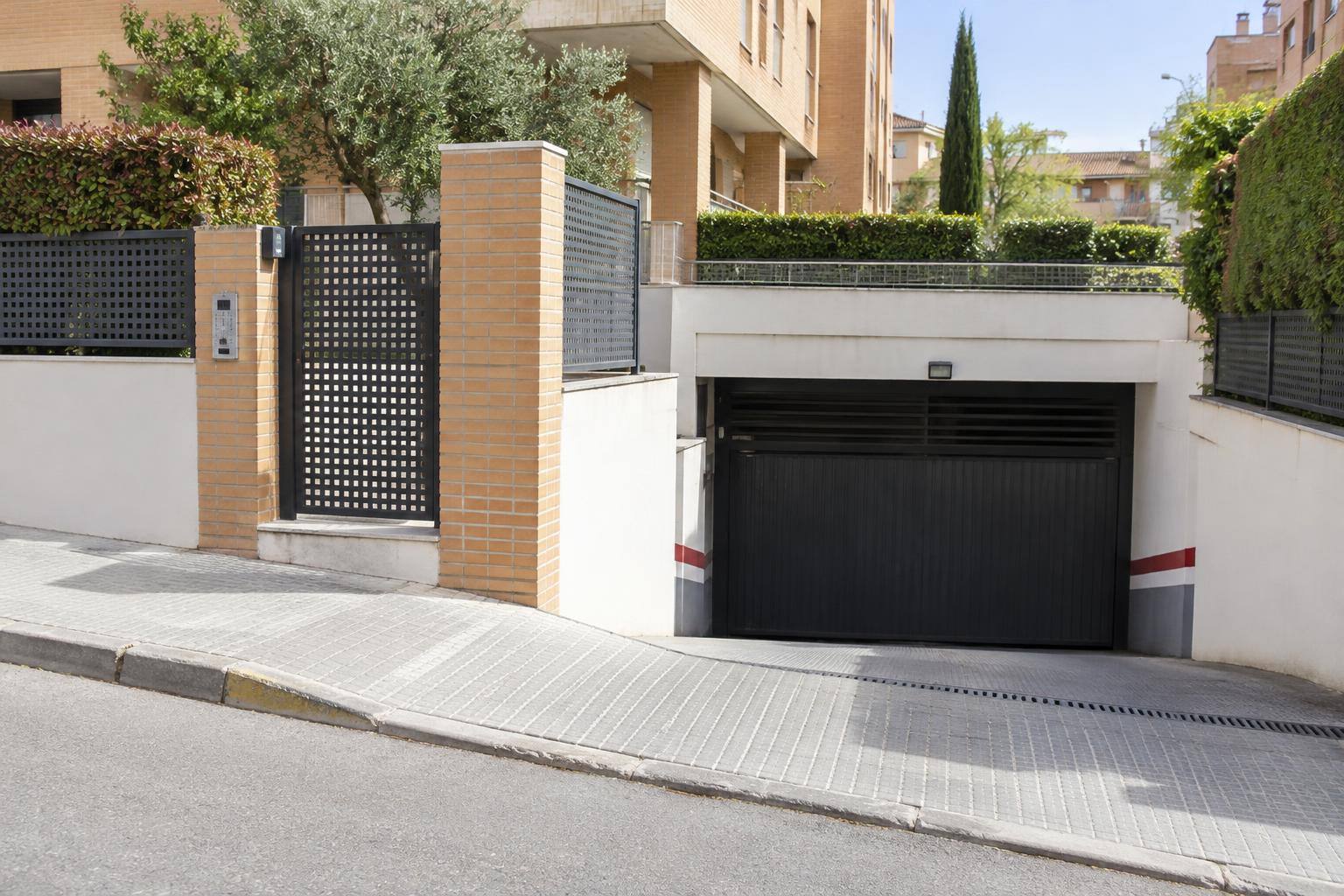 Imagen ilustrativa: Entrada de un garaje en una calle residencial, sin personas ni matrículas visibles.