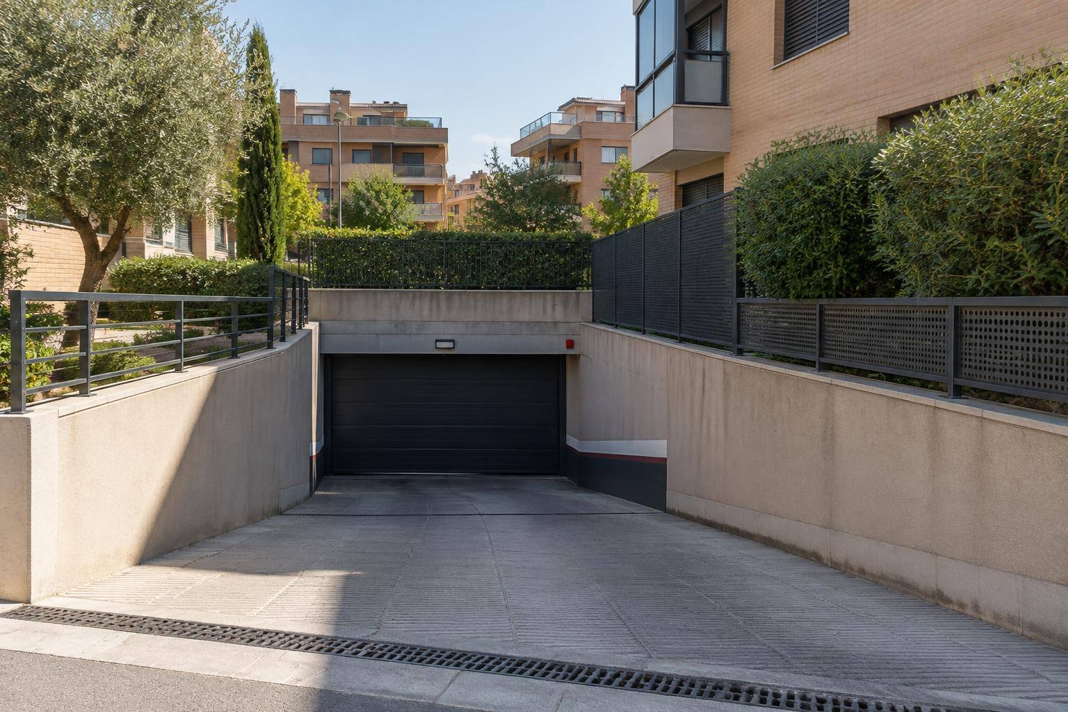 Imagen ilustrativa: Rampa de acceso a un garaje comunitario residencial, sin personas ni matrículas reconocibles.