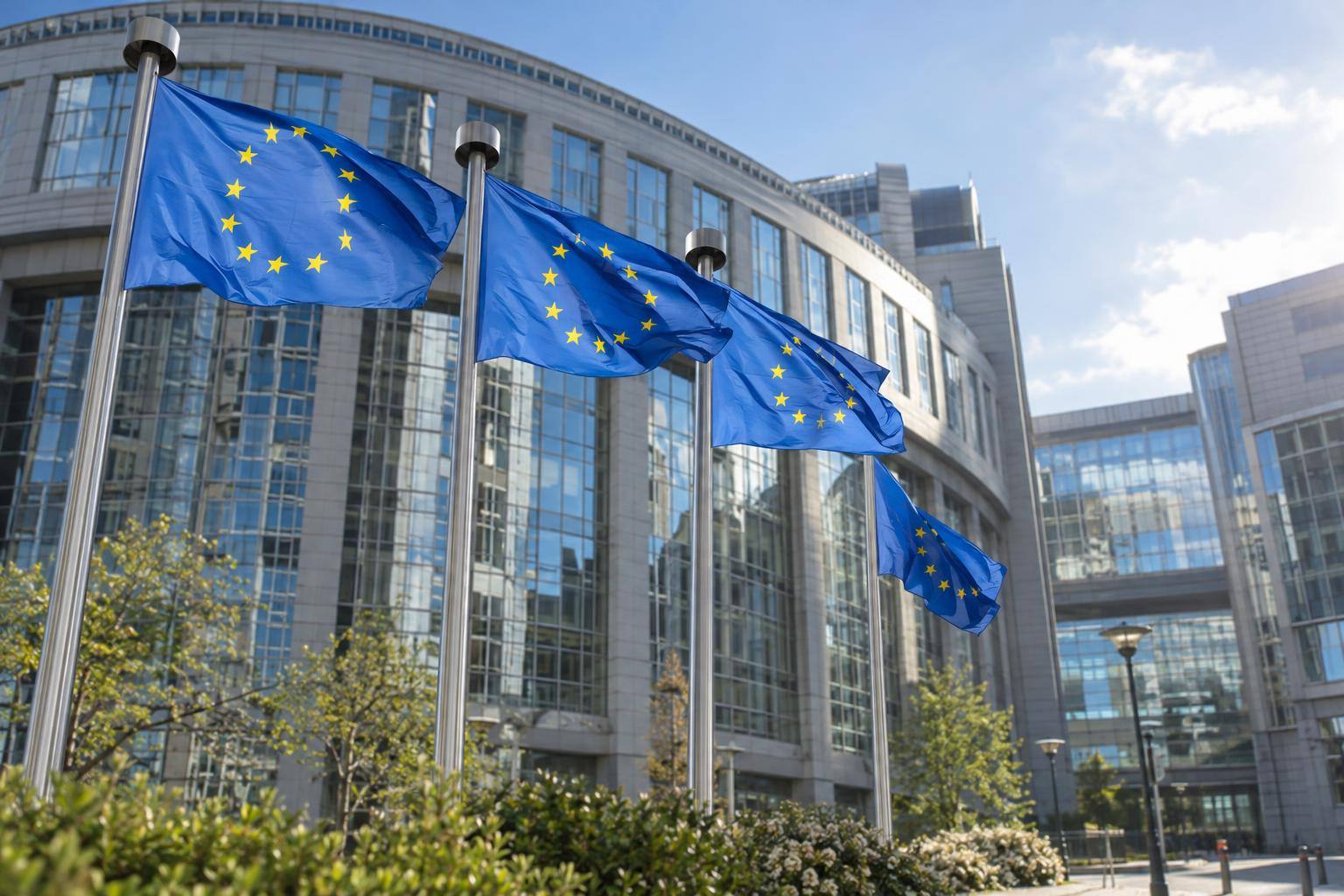 Imagen ilustrativa: Banderas de la Unión Europea ante un edificio institucional en Bruselas, sin personas reconocibles