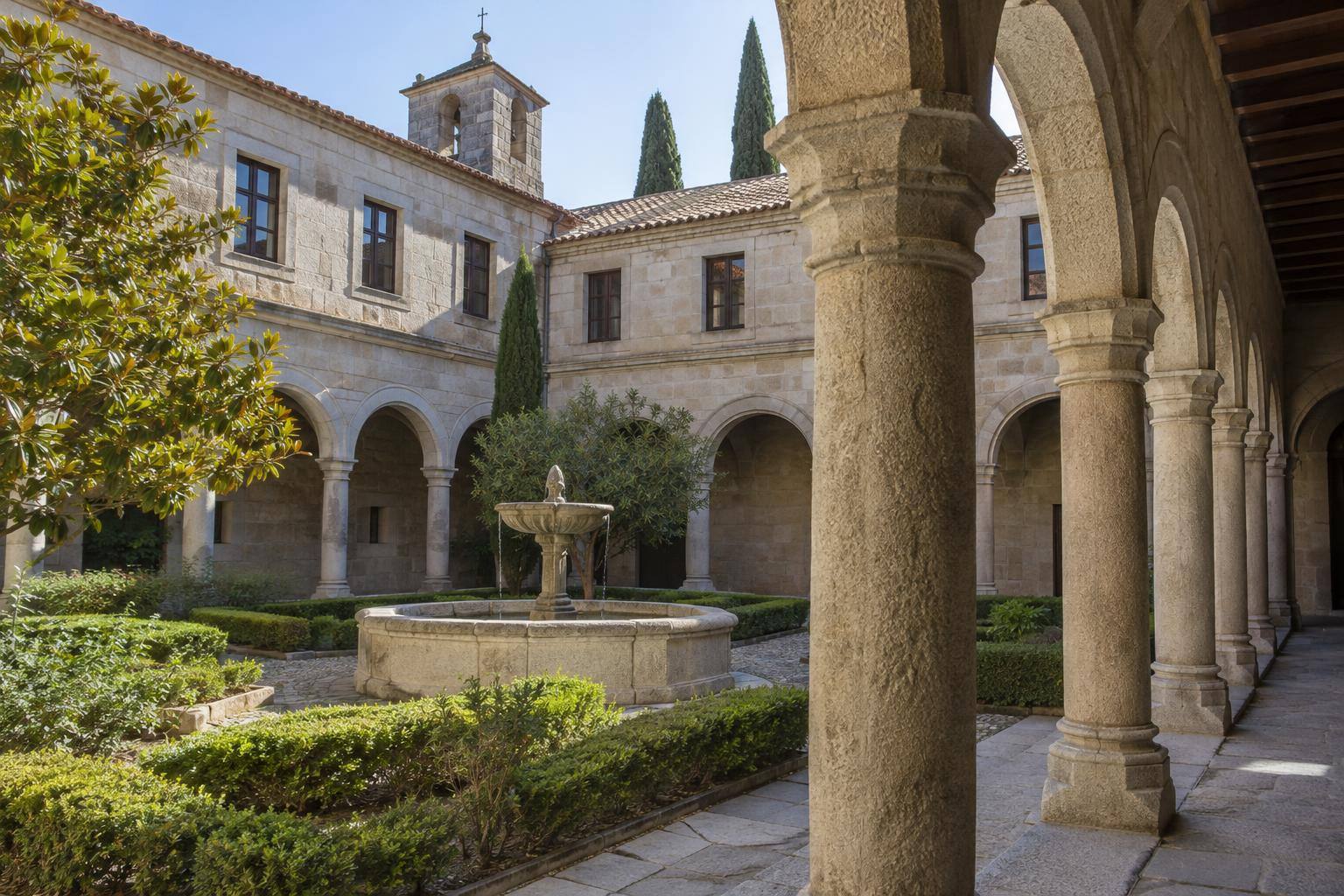 Imagen ilustrativa: Claustro de un monasterio histórico con una fuente de piedra y galerías porticadas, sin personas.