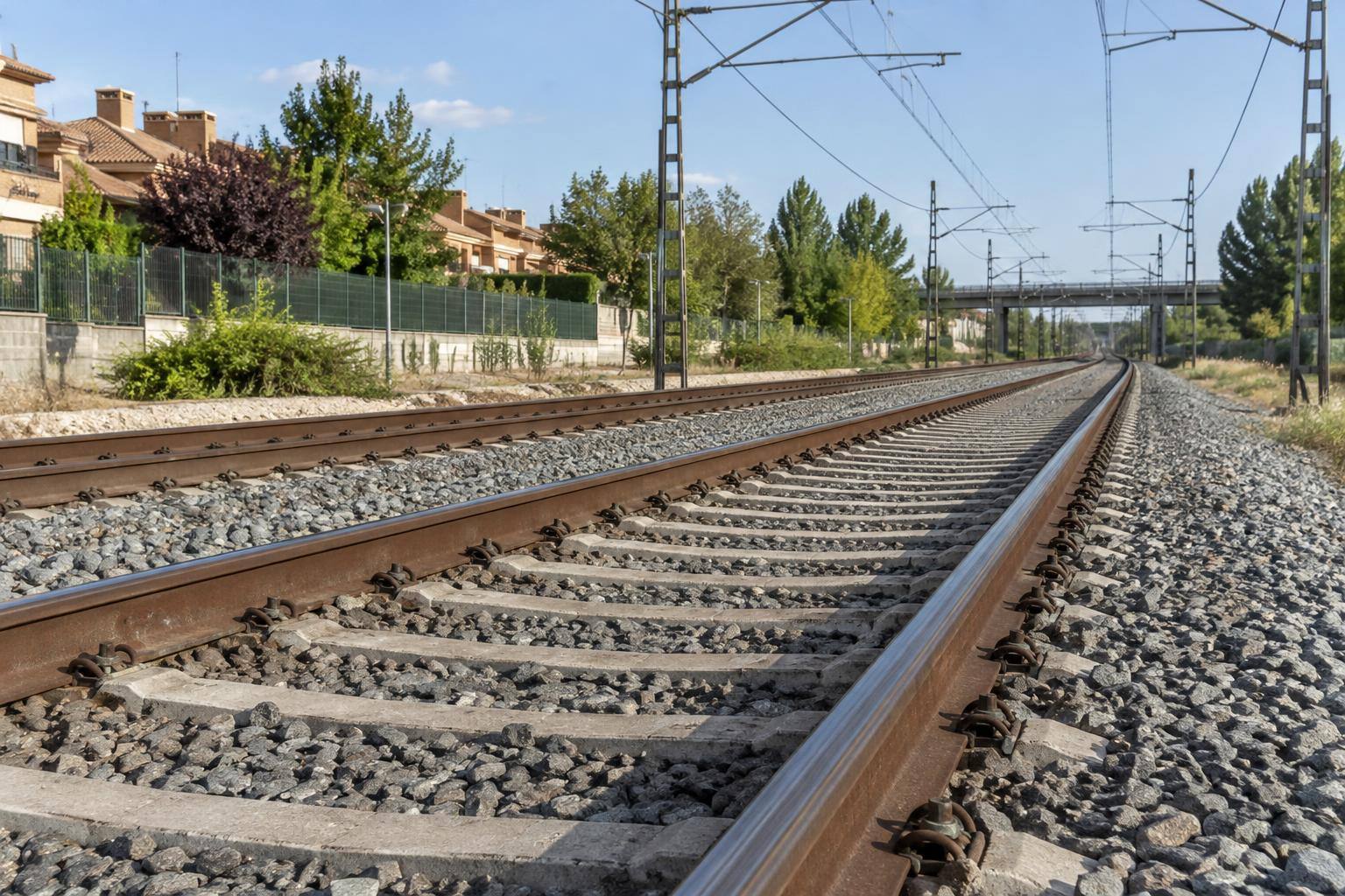 Imagen ilustrativa: Detalle genérico de una vía ferroviaria con carriles, traviesas de hormigón y balasto, sin trenes ni personas.