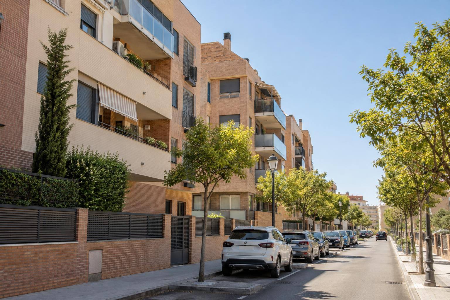 Imagen ilustrativa: Fachadas de bloques de viviendas en una calle urbana andaluza, sin personas reconocibles.