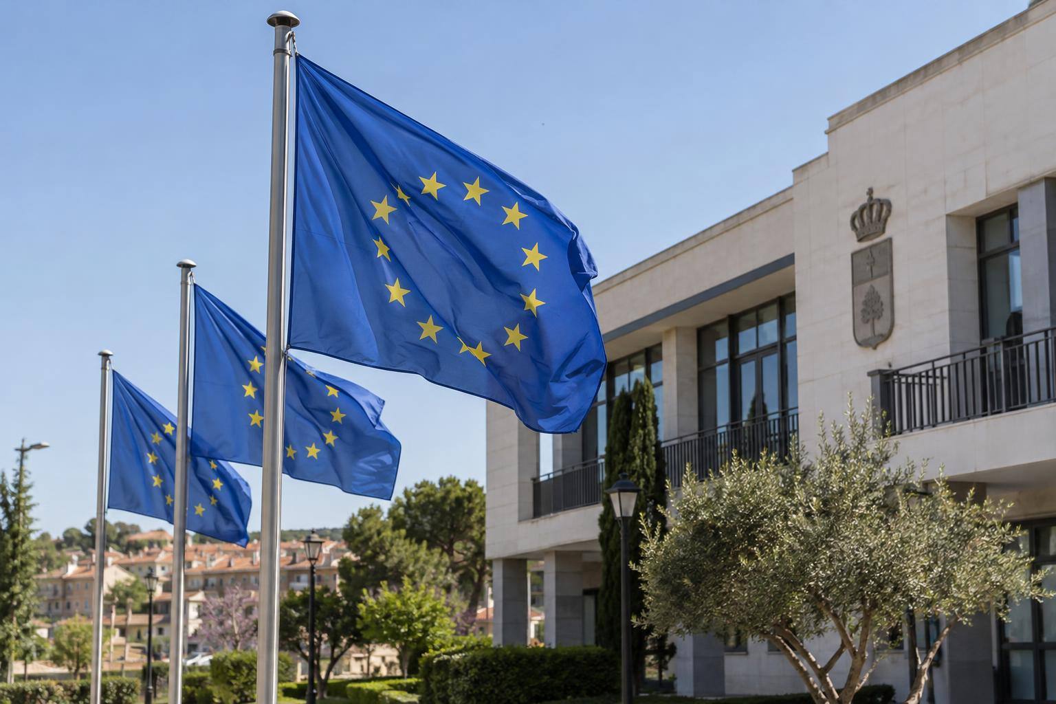 Imagen ilustrativa: Banderas de la Unión Europea ante un edificio institucional, sin personas reconocibles