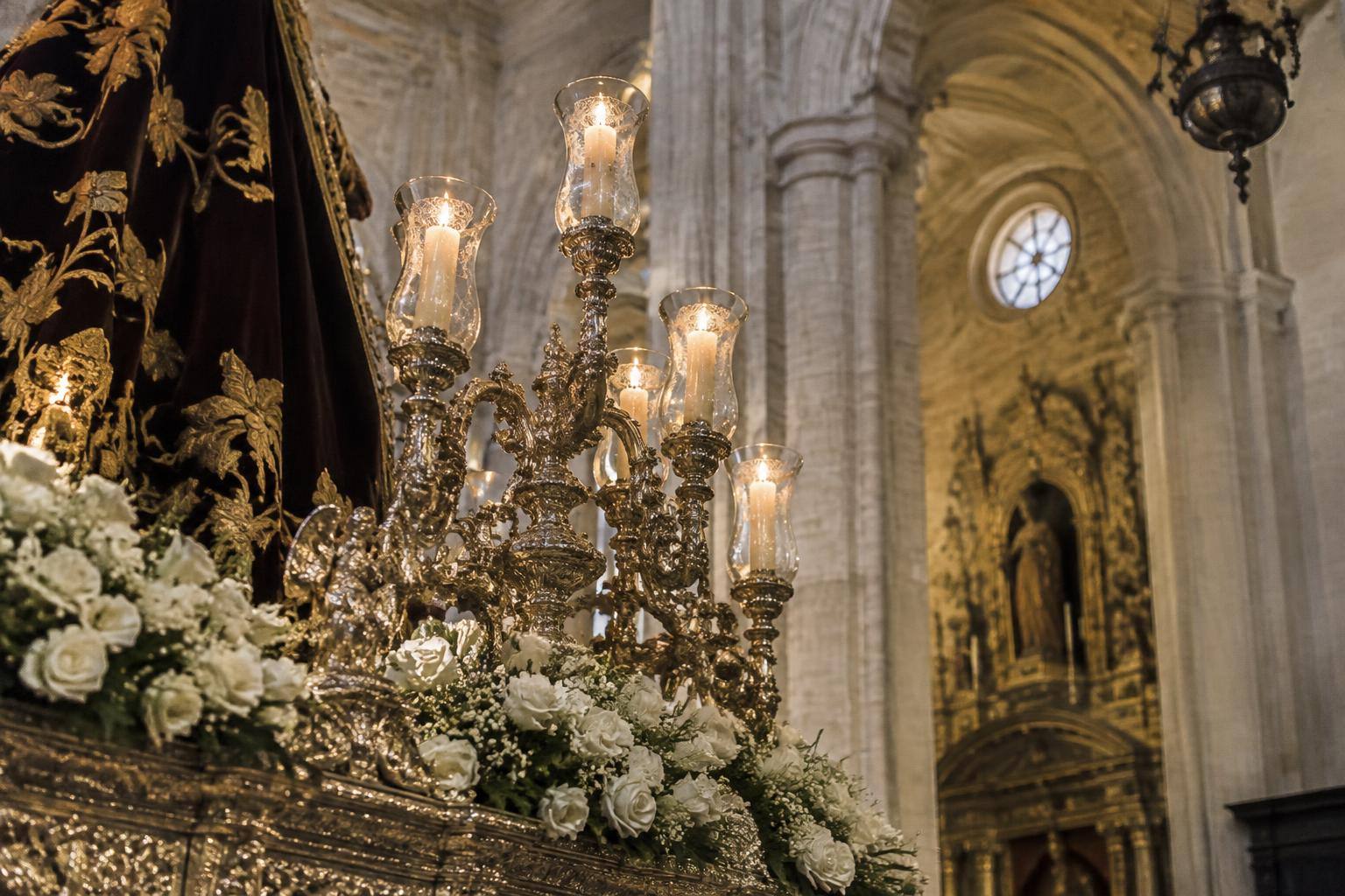 Imagen ilustrativa: Detalle de un paso procesional con candelabros en el interior de una iglesia, sin personas reconocibles