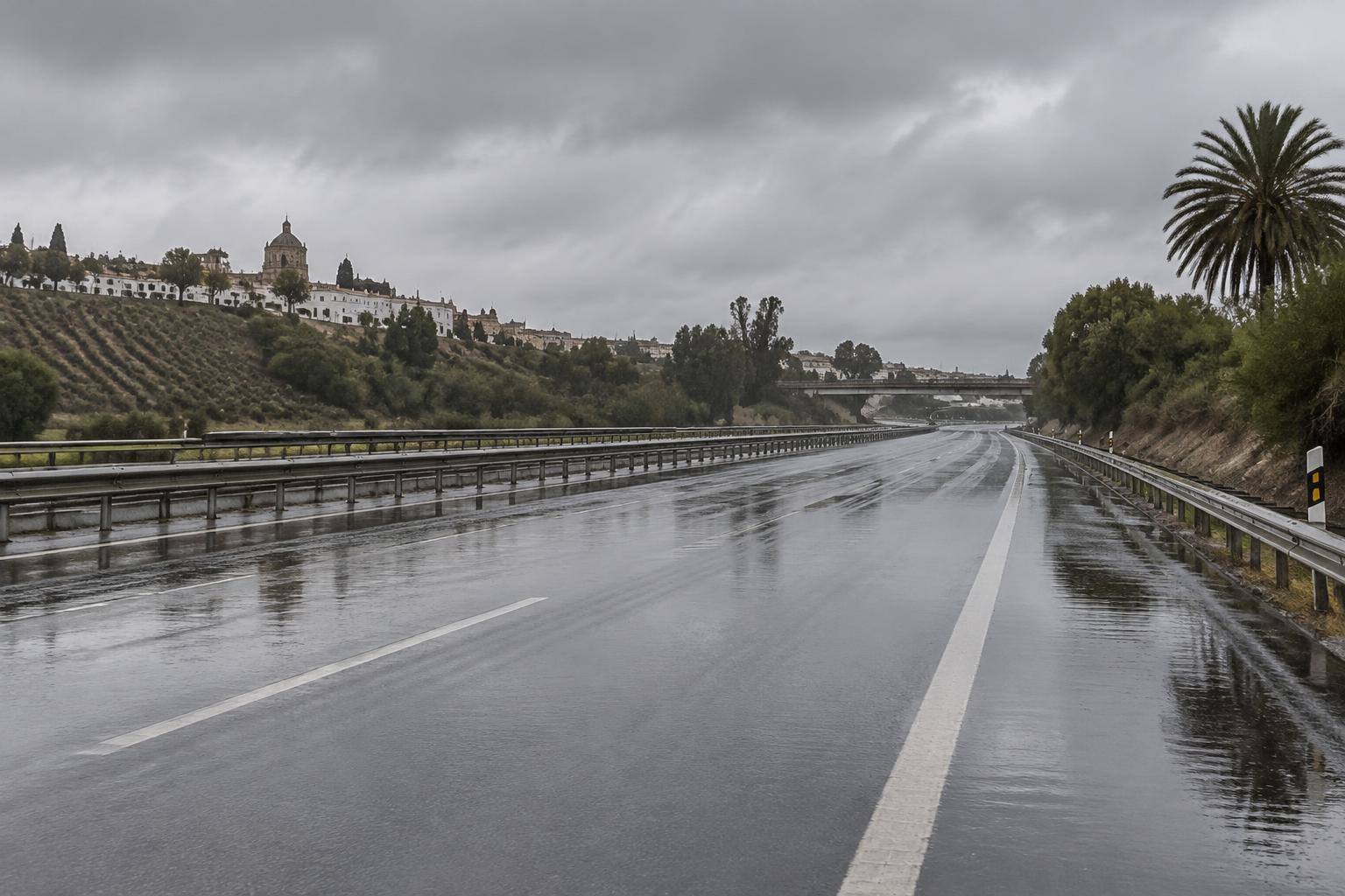 Imagen ilustrativa: Calzada de una autopista con agua acumulada y cielo cubierto, sin vehículos ni personas reconocibles.