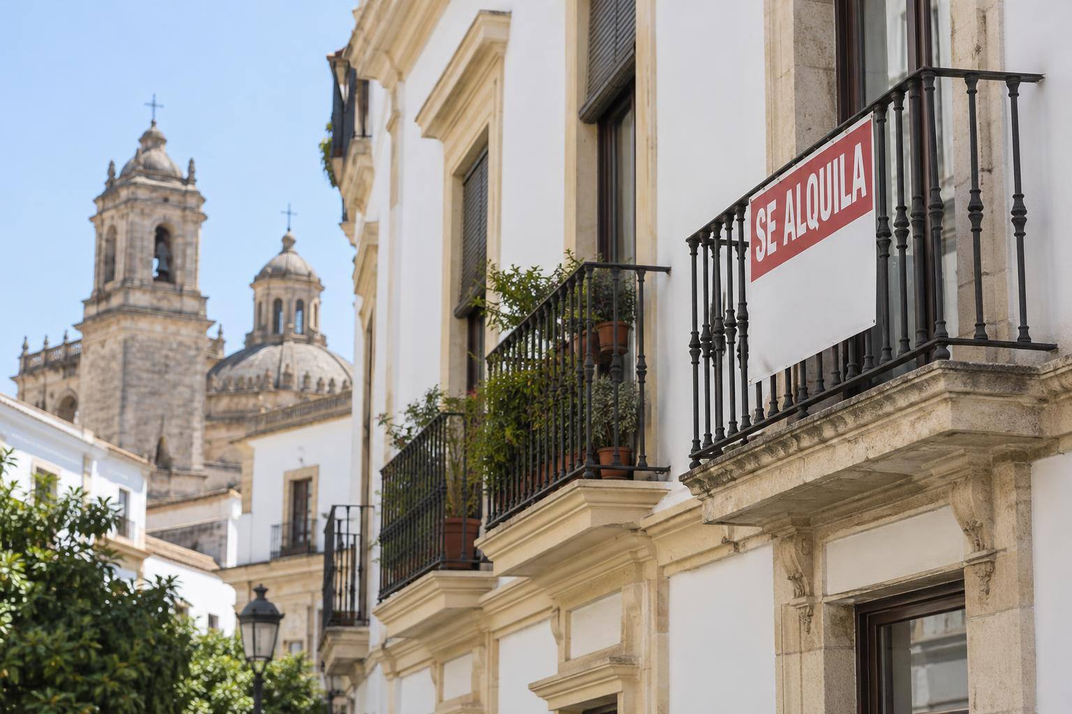 Imagen ilustrativa: Fachada de un edificio residencial con balcones y un cartel genérico de alquiler, sin personas ni datos de contacto visibles