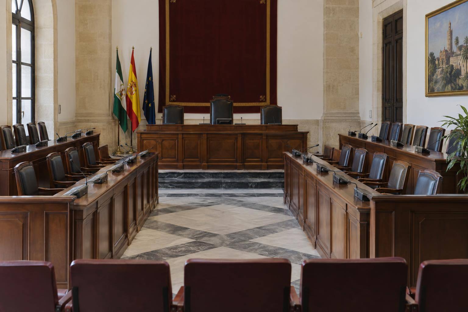 Imagen ilustrativa: Salón de plenos de un ayuntamiento, con escaños vacíos y mesa de presidencia, sin personas ni emblemas identificables.