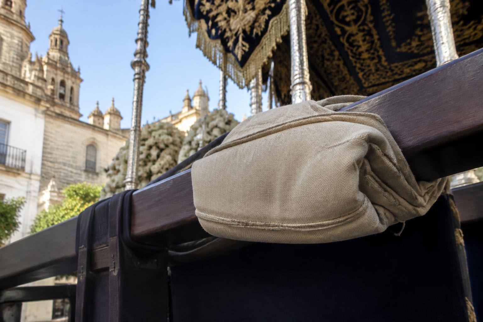 Imagen ilustrativa: Detalle de un costal plegado junto a una trabajadera de madera de un paso de palio, sin personas.