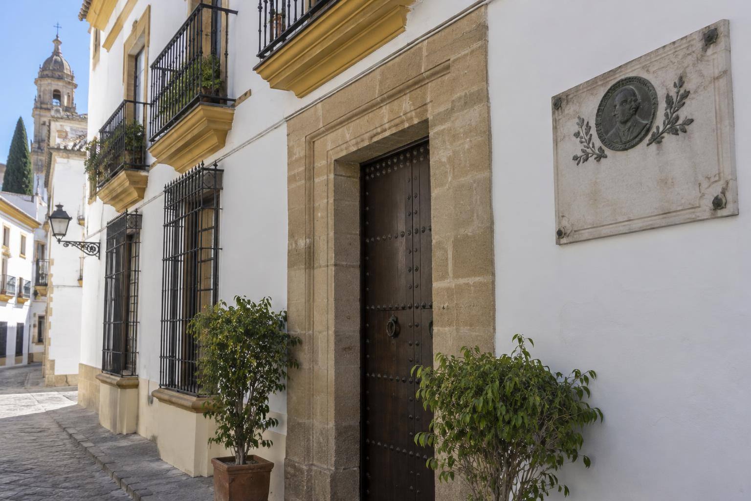 Imagen ilustrativa: Fachada de una casa andaluza con una placa conmemorativa sin texto legible, sin personas.